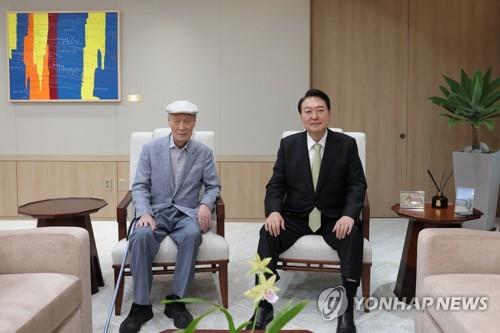 President Yoon Suk Yeol (R) poses for a photo with his father, Yoon Ki-jung, at the presidential office on July 12, 2022, in this file photo provided by the presidential office. (PHOTO NOT FOR SALE) (Yonhap)