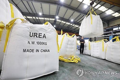 A company officials moves bags of urea used to make urea solution for diesel vehicles at a company in the city of Ansan, Gyeonggi Province, on Dec. 6, 2023. (Yonhap)