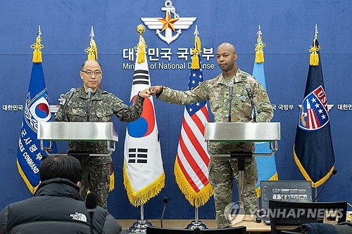 Col. Lee Sung-jun (L), the Joint Chiefs of Staff's spokesperson, bumps fists with Col. Issac Taylor, spokesperson of the U.S. Forces Korea, in a press briefing at the defense ministry's headquarters in central Seoul on Feb. 28, 2024, in this photo provided by the South Korean military. (PHOTO NOT FOR SALE) (Yonhap)