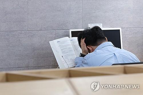 En esta foto de archivo tomada el 23 de junio de 2024, un solicitante de empleo se prepara para un examen en una academia de empleo privada en Seúl. (Yonhap)