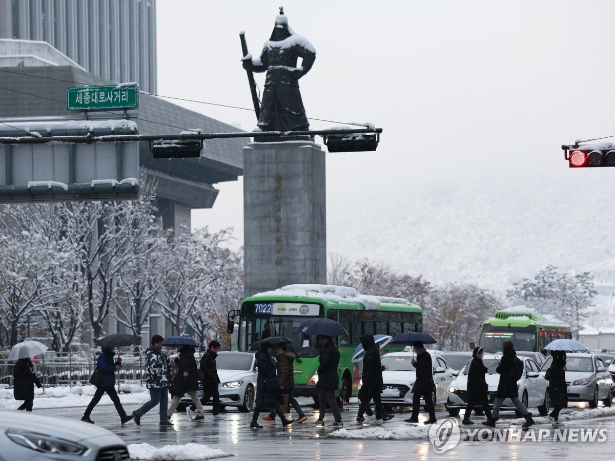 La gente camina por la plaza Gwanghwamun en Seúl el 28 de noviembre de 2024, mientras continúan las fuertes nevadas por segundo día consecutivo. (Yonhap)