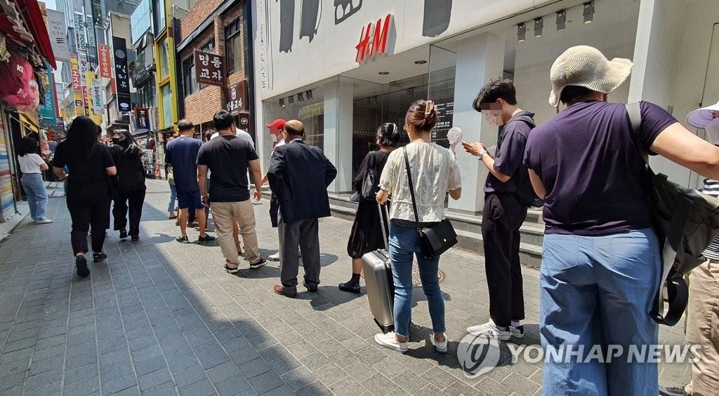 Les gens font la queue avant d'entrer dans un restaurant à Séoul, le 20 juin 2021.