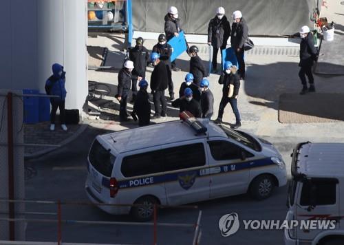 Des responsables de la police et du ministère de l'Emploi et du Travail effectuent une descente dans le bureau de terrain de HDC Hyundai Development Co. à Gwangju, dans le sud-ouest de la Corée du Sud, le vendredi 14 janvier 2022, suite à l'effondrement d'un immeuble en construction.