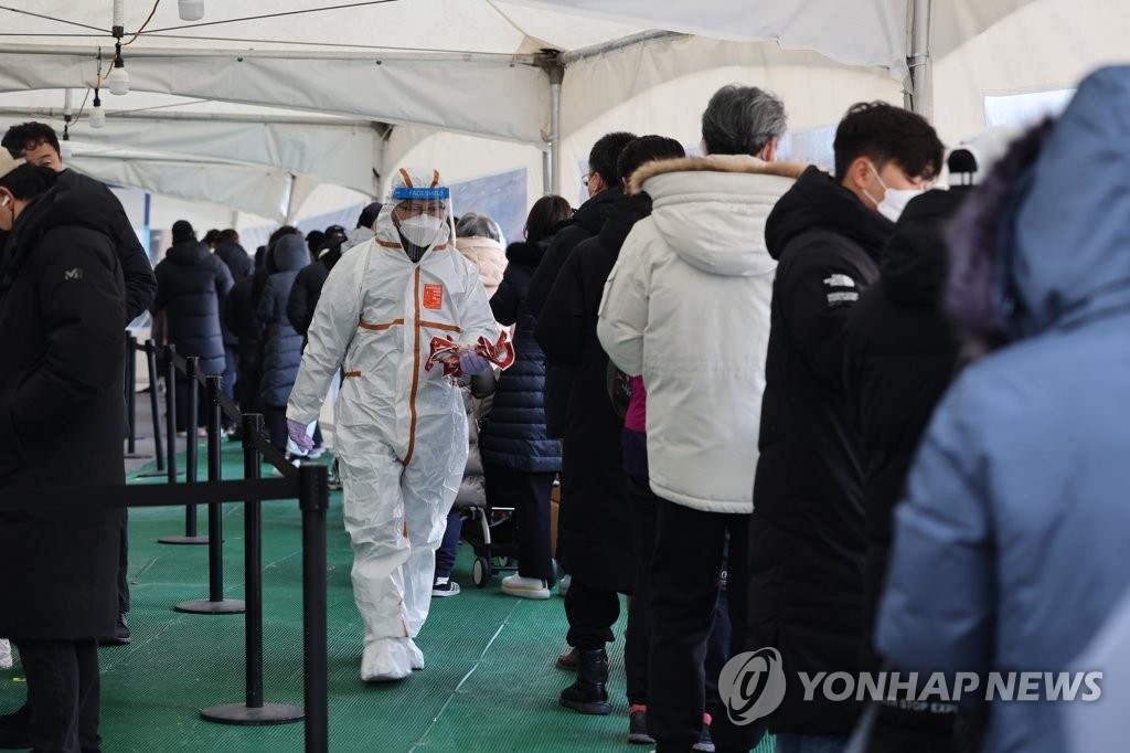 Des personnes font la queue pour passer un test de dépistage du nouveau coronavirus (Covid-19) devant le centre médical public de Songpa, dans le sud-est de Séoul, le jeudi 27 janvier 2022. Le nombre de cas additionnels a atteint 14.518, un record depuis le déclenchement de la pandémie.