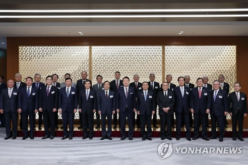 Le président Yoon Suk Yeok (7e à partir de la g.) pose pour une séance photos avec des hommes d'affaires de la Corée du Sud et du Japon lors d'une table ronde à la Fédération des organisations économiques japonaises (Keidanren), le vendredi 17 mars 2023. 