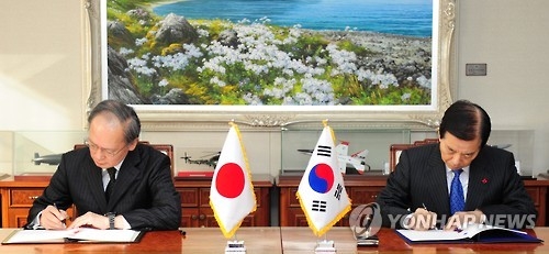 ＧＳＯＭＩＡに署名する韓民求（ハン・ミング）韓国国防部長官（右）と長嶺安政駐韓日本大使＝２３日、ソウル（聯合ニュース）