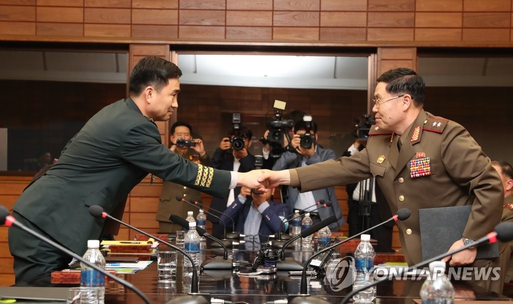 会談の後、共同報道文を交換する韓国側の代表（左）と北朝鮮の代表（韓国国防部提供）＝１４日、ソウル（聯合ニュース）