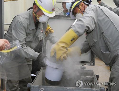 日本から輸入した石炭灰の試料を採取する作業員（資料写真）＝（聯合ニュース）