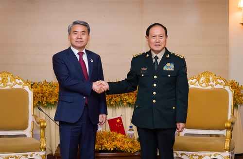 握手する李鐘燮長官（左）と魏鳳和国務委員兼国防相（国防部提供）＝（聯合ニュース）≪転載・転用禁止≫