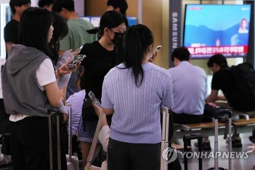 ３１日午前、ソウル駅で警戒警報を確認する人たち＝（聯合ニュース）