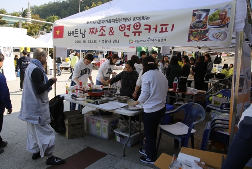 지난 10월 13일 석왕사에서 열린 다문화 나눔장터에서 영담 스님(왼쪽)이 베트남 음식을 맛보고 있다. [석왕사 제공]