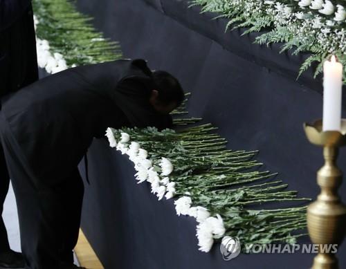 국화에 얼굴 묻고 슬퍼하는 제천참사 유가족 [연합뉴스 자료사진]