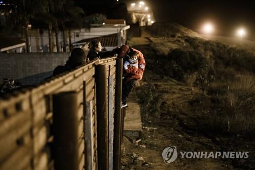 국경장벽 넘는 불법 이민자 가족