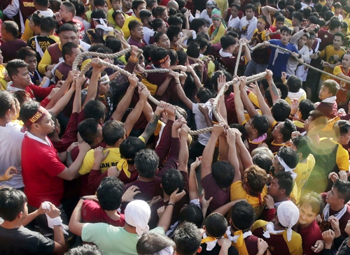 (마닐라 EPA=연합뉴스) '블랙 나자렌'(Black Nazarene) 퍼레이드에서 참가자들이 '검은 예수상'이 실린 수레를 끄는 밧줄을 잡고 있다. 