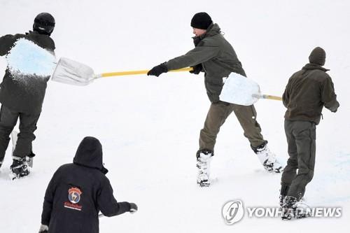 오스트리아 키츠뷔엘에서 열린 알파인스키 월드컵 대회 기간 많은 눈이 쏟아지자 군인들과 자원봉사자들이 2018년 1월 19일 스키 슬로프의 눈을 치우고 있다. [EPA=연합뉴스 자료사진]