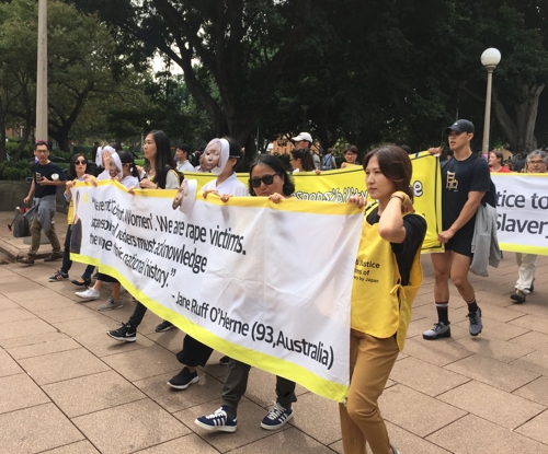 얀 루프-오헤른 할머니의 메시지를 담은 배너를 들고 행진하는 한인 시위대