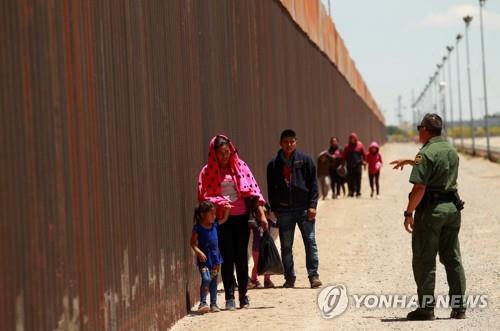 (텍사스 로이터=연합뉴스) 현지시간 15일 중앙아메리카에서 온 이민자가 미국과 멕시코 사이의 국경을 건넌 뒤 국경 순찰 담당자 쪽으로 향하고 있다.