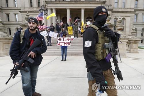 15일(현지시간) 미 미시간주 주도 랜싱의 주의회 의사당 앞에서 소총을 든 시위자들이 자택 대피령에 항의하는 시위를 벌이고 있다. [AP=연합뉴스]