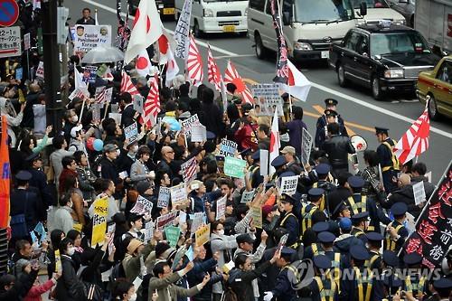 조선학교 보조금 중단을 요구하는 혐한 시위대가 도쿄에서 행진하고 있고 근처에서 시민들이 이에 항의하고 있다. [연합뉴스 자료사진]