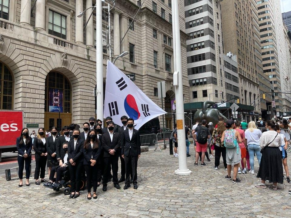 월가 '돌진하는 황소상' 앞에 태극기를 게양하는 한인 청년들