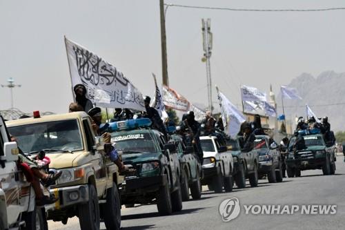 아프가니스탄 남부 칸다하르에서 1일(현지시간) 탈레반 대원들이 아프간전 승리를 자축하며 차량에 탈레반 깃발을 꽂고 퍼레이드를 벌이고 있다. [AFP=연합뉴스]