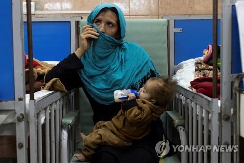  아프간 카불의 한 병원에서 아이를 안고 있는 여성