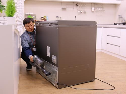 김치냉장고 기계실 먼지를 제거하는 삼성전자서비스 관계자