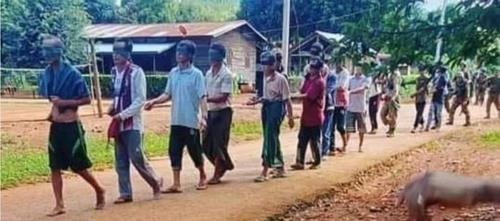 '인간방패' 역할을 위해 눈이 가려진 채 줄에 앞뒤로 묶여 걸어가는 미얀마 시민들의 모습으로 알려진 사진. 뒤로 군인들이 보인다.[이라와디 캡처. 재판매 및 DB 금지] [2021.10.31 송고]
