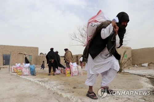 아프간 칸다하르에서 구호 물품을 받아서 옮기는 주민.