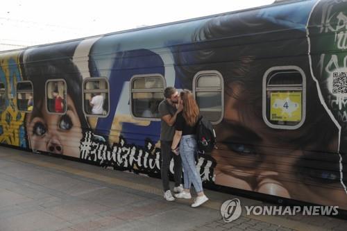 우크라 '승리를 향한 열차' 앞에서 입맞춤하는 연인