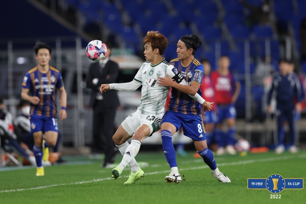 전북 김진수(왼쪽)와 울산 아마노와 공을 다투는 모습.
