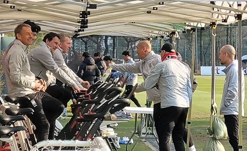 훈련 뒤 사이클 타며 이야기 나누는 클린스만 감독(왼쪽)과 코치들