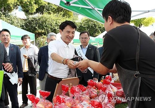 김진태 강원지사가 11일 강원도청 앞 광장에서 열린 추석 맞이 직거래 장터를 찾아 농산물을 구매하고 있다. [강원도 제공·재판매 및 DB 금지]