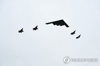트럼프, 푸틴에 힘 과시?…스텔스폭격기 비행·최강 전투기 도열