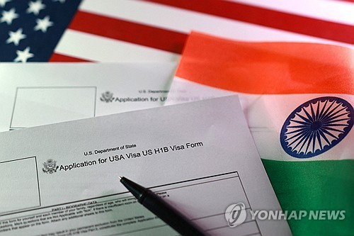 미국과 인도 국기를 배경으로 놓여진 미국의 H-1B 비자 양식