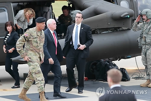 El vicepresidente de Estados Unidos, Mike Pence (centro), baja de un helicóptero en una base militar estadounidense cerca de la frontera intercoreana, antes de visitar la aldea de la tregua de Panmunjeom. (Foto del cuerpo de prensa)