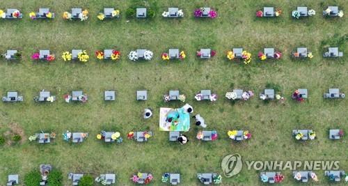 Las personas rinden tributo a sus ancestros en un cementerio en Gwangju, a 329 kilómetros al sur de Seúl, el 21 de septiembre de 2021, en la festividad del Chuseok, la celebración coreana de la cosecha de otoño.