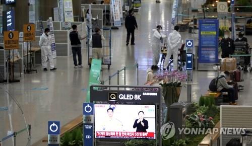 La foto, tomada el 1 de diciembre de 2021, muestra a funcionarios sanitarios, vestidos con trajes protectores, trabajando en el Aeropuerto Internacional de Incheon, al oeste de Seúl.