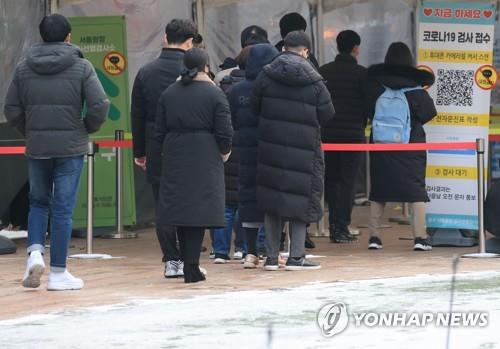 Las personas esperan en fila para someterse a las pruebas del COVID-19, el 29 de diciembre de 2021, en una clínica provisional, en Seúl.