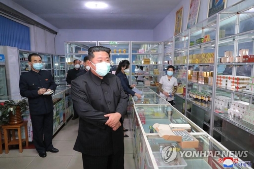 La foto sin fechar, publicada, el 16 de mayo de 2022, por la KCNA, muestra al presidente del Comité de Asuntos de Estado norcoreano, Kim Jong-un (frente), utilizando una mascarilla de protección sanitaria ante el brote de COVID-19, mientras inspecciona una farmacia, en Pyongyang. (Uso exclusivo dentro de Corea del Sur. Prohibida su distribución parcial o total)