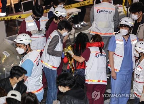 Los trabajadores médicos atienden a las víctimas de la avalancha humana, el 30 de octubre de 2022, en el barrio de Itaewon, en Seúl, ocurrida durante las celebraciones de la Noche de Brujas.