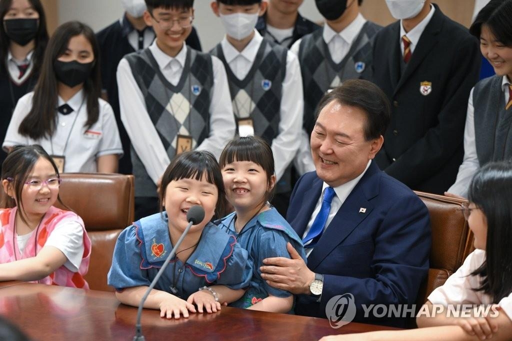 Yoon ofrece a un grupo de niños una visita guiada a la oficina presidencial