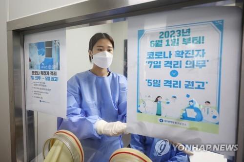 Una trabajadora médica pone un aviso, el 31 de mayo de 2023, en una instalación de tratamiento del COVID-19, en Gwangju, a 267 kilómetros al sur de Seúl, el cual notifica que, a partir del 1 de junio, el período de aislamiento se reducirá a cinco días como recomendación, frente al requisito obligatorio de siete días.
