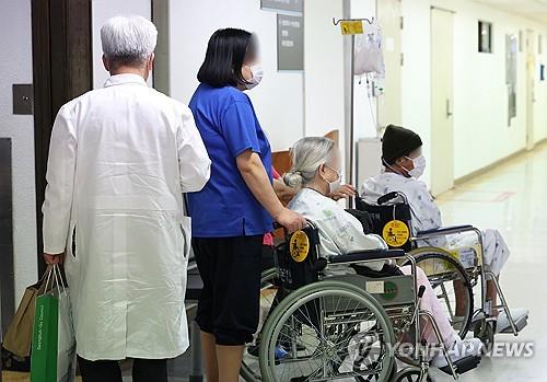 To zdjęcie do pliku, wykonane 22 marca 2024 r., przedstawia pacjentów siedzących na wózkach inwalidzkich w szpitalu w Seulu.