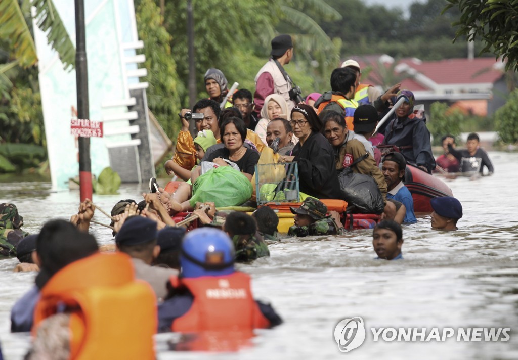 2019년 1월 23일 인도네시아 남술라웨시 주 마카사르에서 홍수가 발생하자 주민들이 뗏목에 실려 안전한 지대로 옮겨지고 있다. [AP=연합뉴스]