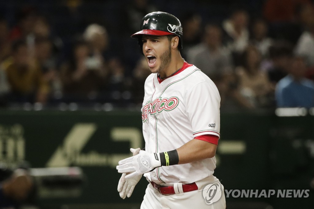 United States' Andrew Vaughn scores on a single hit by Robert Dalbec in the  seventh inning of the Premier12 baseball tournament bronze-medal game  against Mexico at Tokyo Dome in Tokyo Sunday, Nov.