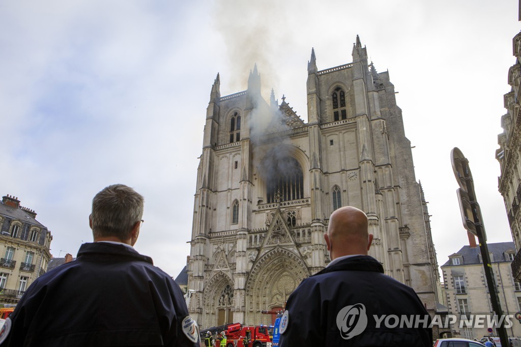 지난 18일 프랑스 경찰이 낭트 대성당의 화재 진압 장면을 지켜보고 있다.[AP=연합뉴스 자료사진]