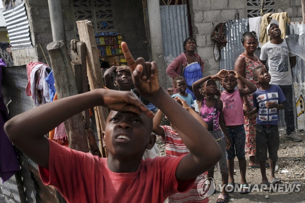 구호물자 실은 헬기 올려다 보는 아이티 지진 피해자들