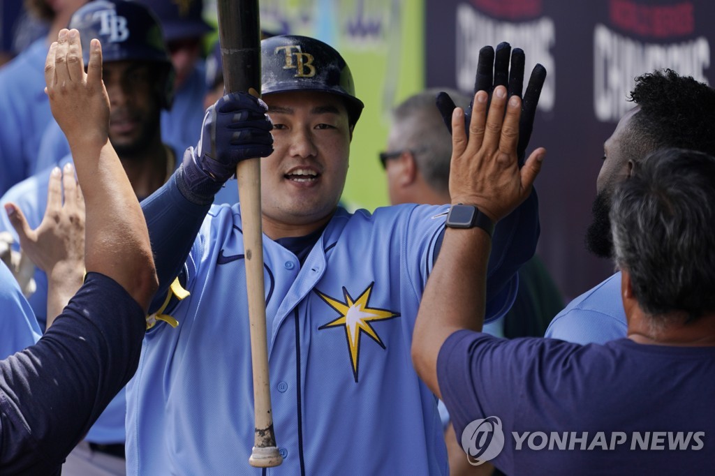 In this Associated Press file photo from March 31, 2022, Choi Ji-man of the Tampa Bay Rays (C) is congratulated by teammates in the dugout after hitting a sacrifice fly against the Atlanta Braves during the top of the third inning of a Major League Baseball spring training game at CoolToday Park in North Port, Florida. (Yonhap)