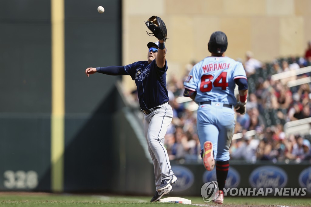 In this Associated Press photo, Tampa Bay Rays first baseman Choi Ji-man (L) catches the throw from third baseman Yandy Diaz after Minnesota Twins' Jose Miranda (R)) hit a ground ball during the bottom of the ninth inning of a Major League Baseball regular season game at Target Field in Minneapolis on June 12, 2022. (Yonhap)